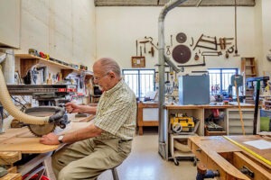A resident passes time working in the woodshop in