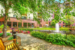 A bench and walkway next to a water feature at Covenant Living Golden Valley.